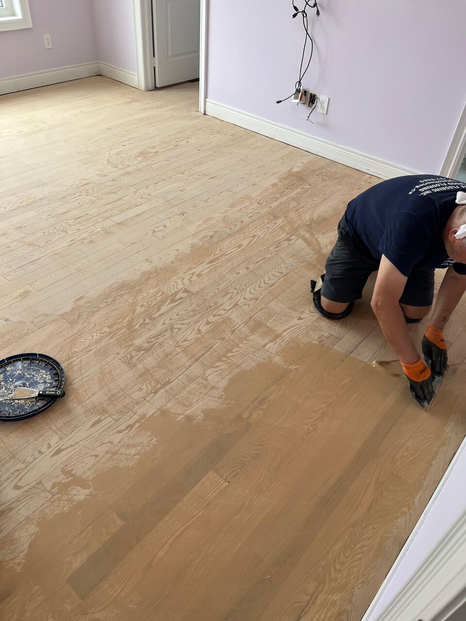 Hardwood floor filler being applied by a worker in Capitol Hill, Washington, DC home