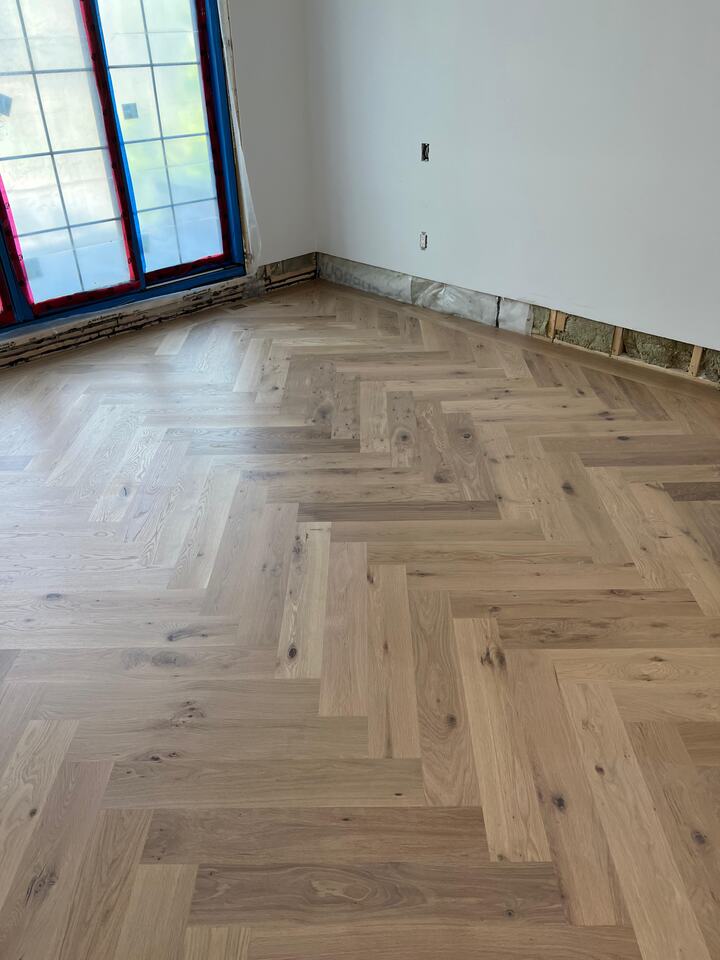 Chevron-patterned hardwood stairs with painted white risers refinished with a rich tone in Alexandria, Virginia home